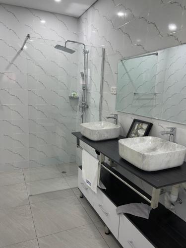 卢萨卡Meanwood Place Apartments的浴室设有2个水槽和镜子