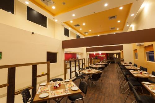 艾哈迈达巴德Ginger Ahmedabad Vastrapur的餐厅内带桌椅的用餐室