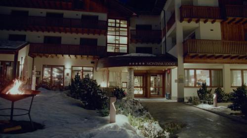 拉特乌伊莱Montana Lodge & Spa, by R Collection Hotels的大楼前有雪的酒店