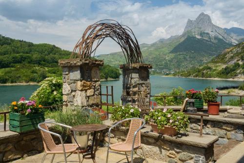 拉努萨Hotel La Casueña的湖景庭院配有桌椅