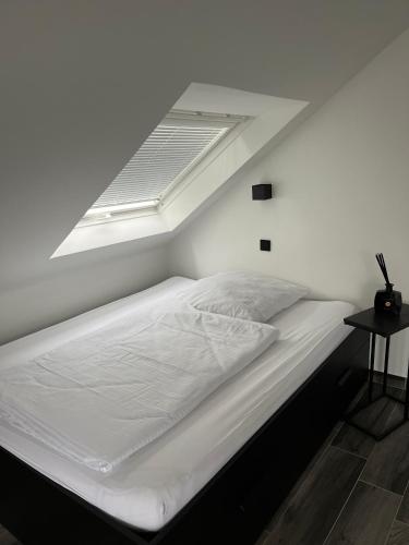 鲁尔河畔米尔海姆Haus Gabor的卧室内的白色床和天窗
