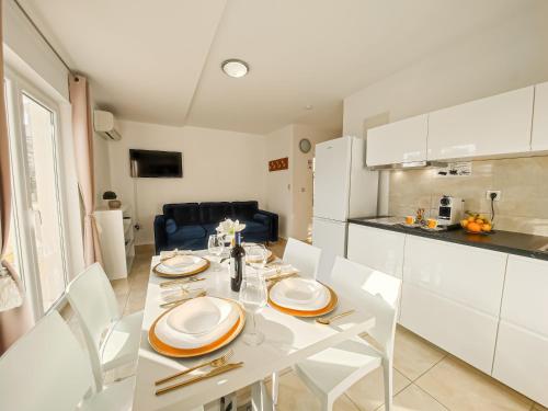 布雷拉Apartments - Villa Sabrina的厨房以及带白色桌椅的用餐室。