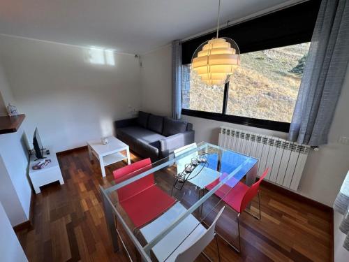 埃尔塔特Apartament Narcis 2.5 - 5p - Ransol - Zona Grandvalira的客厅配有玻璃桌和红色椅子
