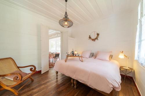 萨拉济La Villa Blanche, Hell-Bourg的一间卧室配有一张床、一把椅子和一张桌子