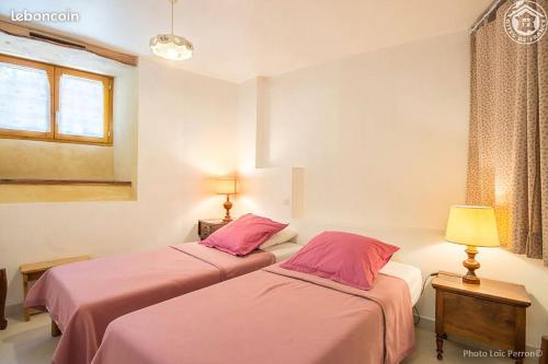 瓦尔梅尼耶Gite Les Nièces - 4-6pers 57m2 Valmeinier - Ski的配有粉红色床单的客房内的两张床
