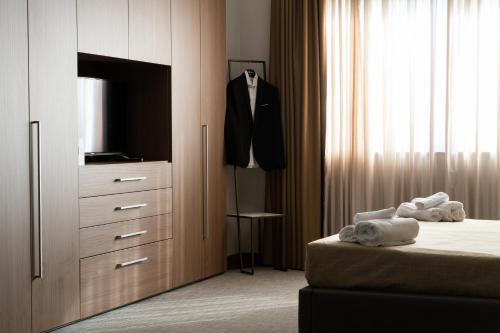 TeverolaBuilding Hotel的一间卧室配有一张床和一个带电视的梳妆台。