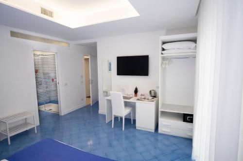 索伦托Domus Sole的白色的客房配有书桌和电视。