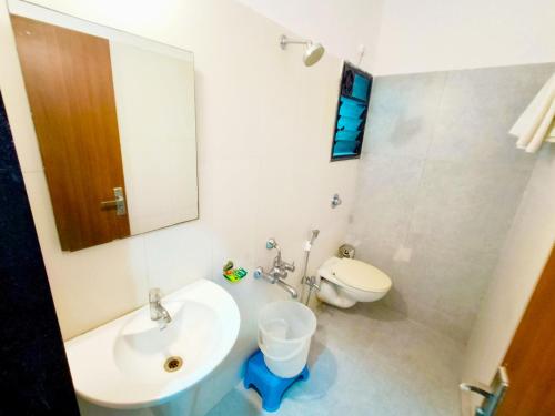 舍地SAI SRUSHTI by NEEM SQUARE的一间带水槽、卫生间和镜子的浴室
