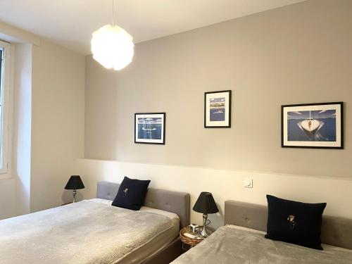 戛纳Cannes Old Port, Seafront & Seaview , fast wifi, best AC的一间卧室设有两张床,墙上有两盏灯。