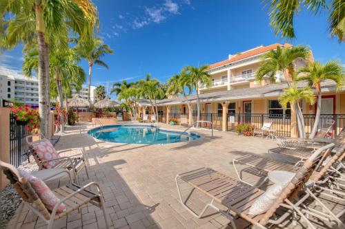 圣徒皮特海滩Walkable to Restaurants and Steps to the Beach! - Coconut Villa's Suite 10的一个带游泳池、椅子和棕榈树的度假村