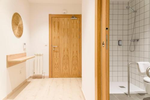 维多利亚-加斯特伊兹APARTHOTEL SALBURUA的一间带卫生间和木门的浴室