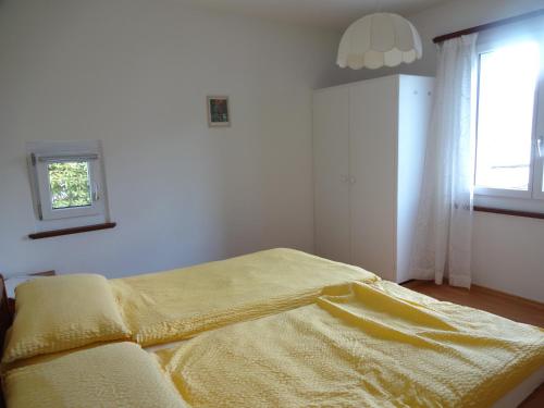 洛迦诺天堂度假公寓的一间卧室配有一张黄色毯子床