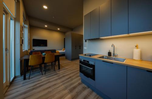 雷克雅未克Center Apartments - Esja的厨房配有蓝色橱柜和桌椅