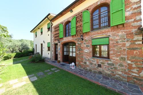 卡潘诺里Agriturismo Corte Stefani的一座砖砌建筑,设有绿色百叶窗和庭院