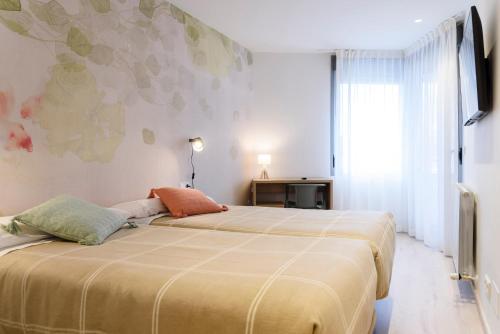 维多利亚-加斯特伊兹APARTHOTEL SALBURUA的一间卧室设有两张床和窗户。