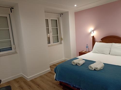 里斯本马蒂姆莫尼兹28号旅馆的一间卧室配有一张床,上面有两条毛巾