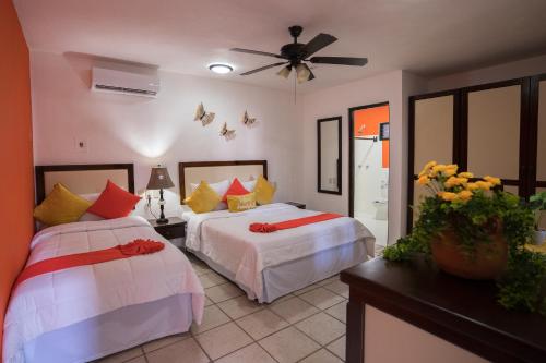 普拉亚卡门波萨达马里波萨第五大道精品酒店的一间卧室配有两张床和吊扇
