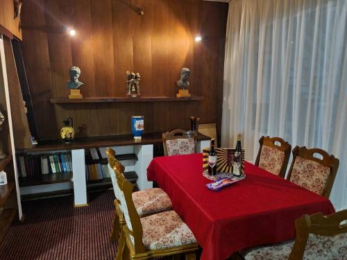 帕莱Kuća za odmor Niki的一间带红色桌布的餐桌的用餐室