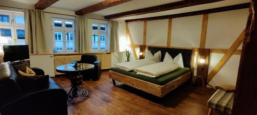 韦尼格罗德Traditions - Hotel "Zur Tanne"的卧室配有床、桌子和窗户。