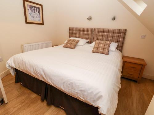 哈肯Tyn-y-Mynydd Bach的一间卧室配有带白色床单和枕头的床。