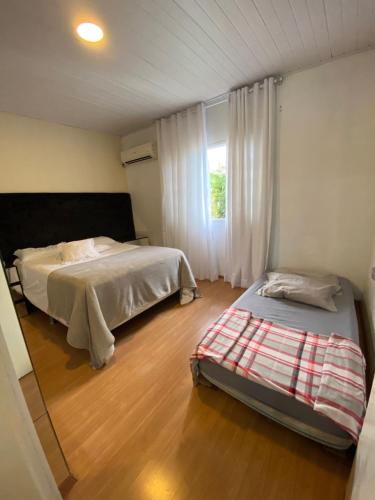 塞尔苏拉穆斯州长镇Casa conchas das Caravelas的一间卧室设有两张床和窗户。