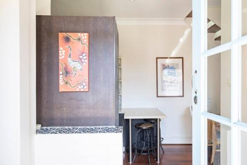 悉尼Steps from Manly Beach的走廊上挂着一张桌子和一张墙上的照片