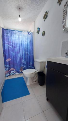 阿卡普尔科Casa Acá Diamante Gaviotas的浴室设有卫生间和蓝色的浴帘。