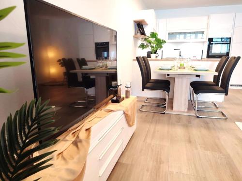 上陶恩Modern Mountain Apartment - free parking & sauna的客厅配有餐桌和大电视