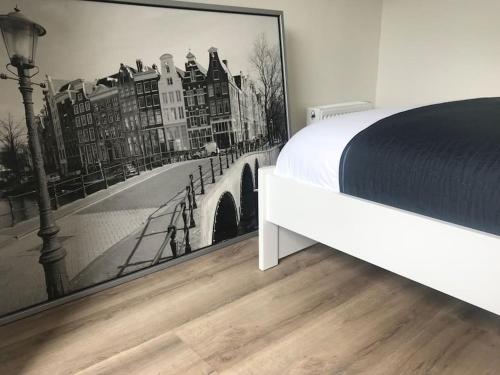 阿斯米尔Quiet Waterloft near Amsterdam and Schiphol WS17的一间卧室配有一张床,并画着一座桥