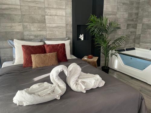 圣西普里安Superbe appartement avec balnéo.的两只天鹅用毛巾制成,坐在床上