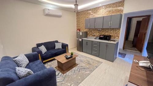艾卜哈فيو إن للشقق الفندقية - المحالة的一间带蓝色沙发的客厅和一间厨房