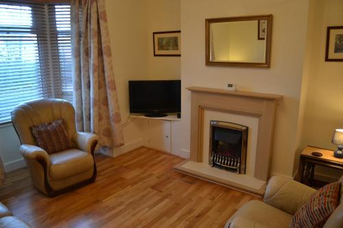 卡菲利Entire 3 bedroom house near Caerphilly station的客厅设有壁炉和电视。