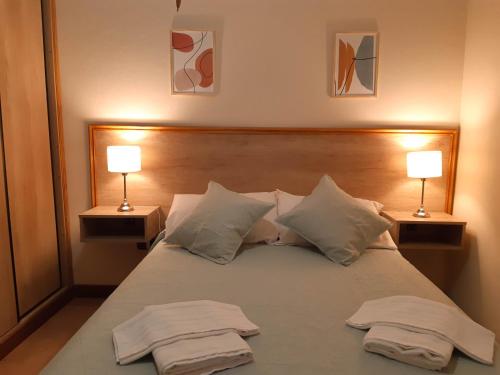 波特雷罗德洛斯弗内斯Departamento Las Margaritas的一间卧室,床上配有两条毛巾和两盏灯