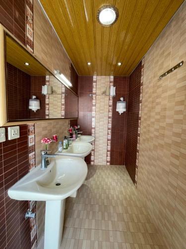 Al Muţayrifīمنتجع اكواخ النخيل的浴室设有2个水槽和2面镜子
