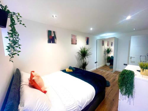 珀利Smart/ Modern one bedroom flat的一间卧室,配有一张床和一些盆栽植物