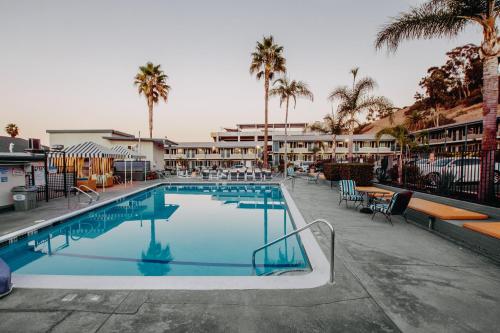 圣地亚哥圣地亚哥阿特伍德汽车旅馆 - 海洋世界/动物园的一个带椅子和棕榈树的度假村游泳池