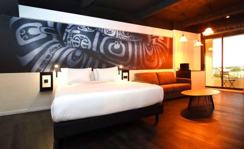 帕皮提Boutique Hôtel Kon Tiki Tahiti的卧室配有一张白色的大床和一张沙发。