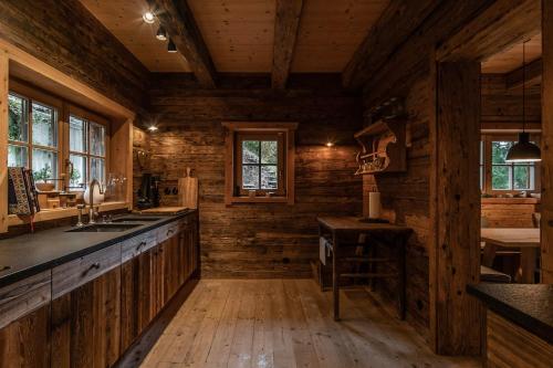 凯撒山麓舍福Luxury old wood mountain chalet in a sunny secluded location with gym, sauna & whirlpool的小木屋内的厨房设有木墙