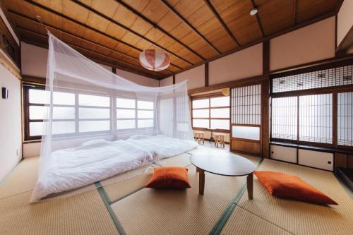 MitoyoLarge family accommodation Tsuji family - Vacation STAY 20952v的卧室配有床、桌子和窗户。