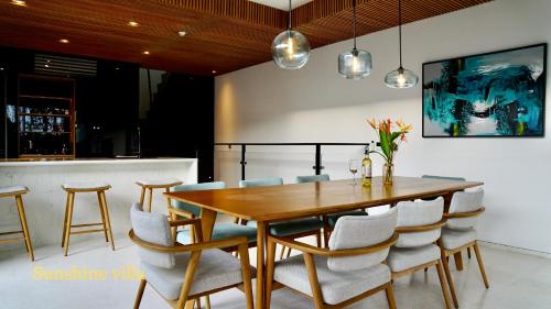 富国Westcoast PQ Sunshine spacious 3BR private pool villa的一间带木桌和椅子的用餐室