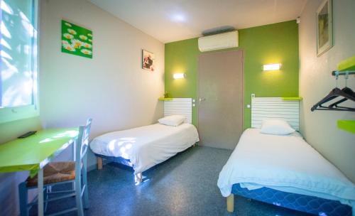 马诺斯克马诺斯克美丽阿尔卑斯酒店的绿墙客房内的两张床