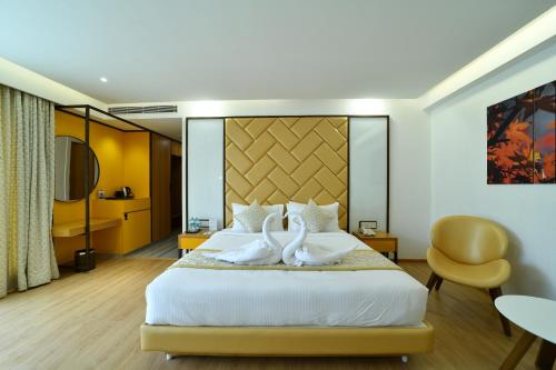 班加罗尔The President Hotel, kumarapark的两个天鹅坐在酒店房间的床边