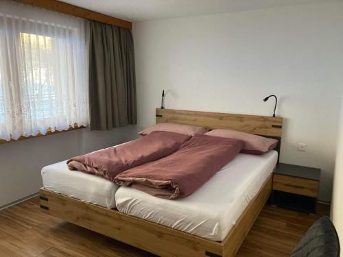 萨斯阿尔马格尔Haus Castello的一间卧室配有一张带两个枕头的木床