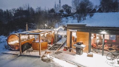 CholerzynCosta del Kryspi Całoroczne Domy na Wodzie的雪覆盖的房子,在雪中设有热水浴缸
