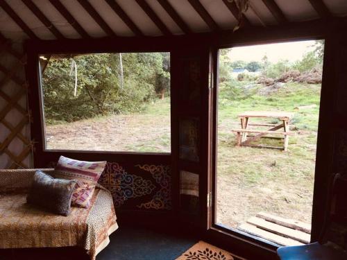 LlanbrynmairMongolian yurt sleeping 2+2 with outdoor space的透过窗户可欣赏到野餐桌景色的客房