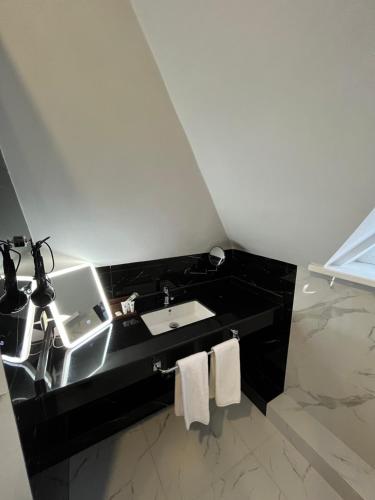 QaskelengResident Hotel Kaskelen的一间带水槽和黑色台面的浴室