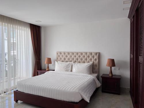 暹粒SSK Apartment的卧室配有一张带白色床单和枕头的大床。