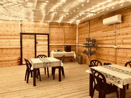 Be'er Milkaנירוונה במדבר的用餐室设有桌椅和木墙