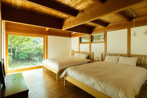佐世保木木木木 KIGI MOKU MOKU的带窗户的客房内的两张床