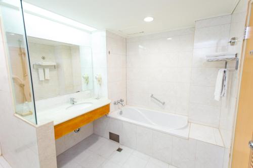 员林雅迪商务旅馆的白色的浴室设有浴缸和水槽。